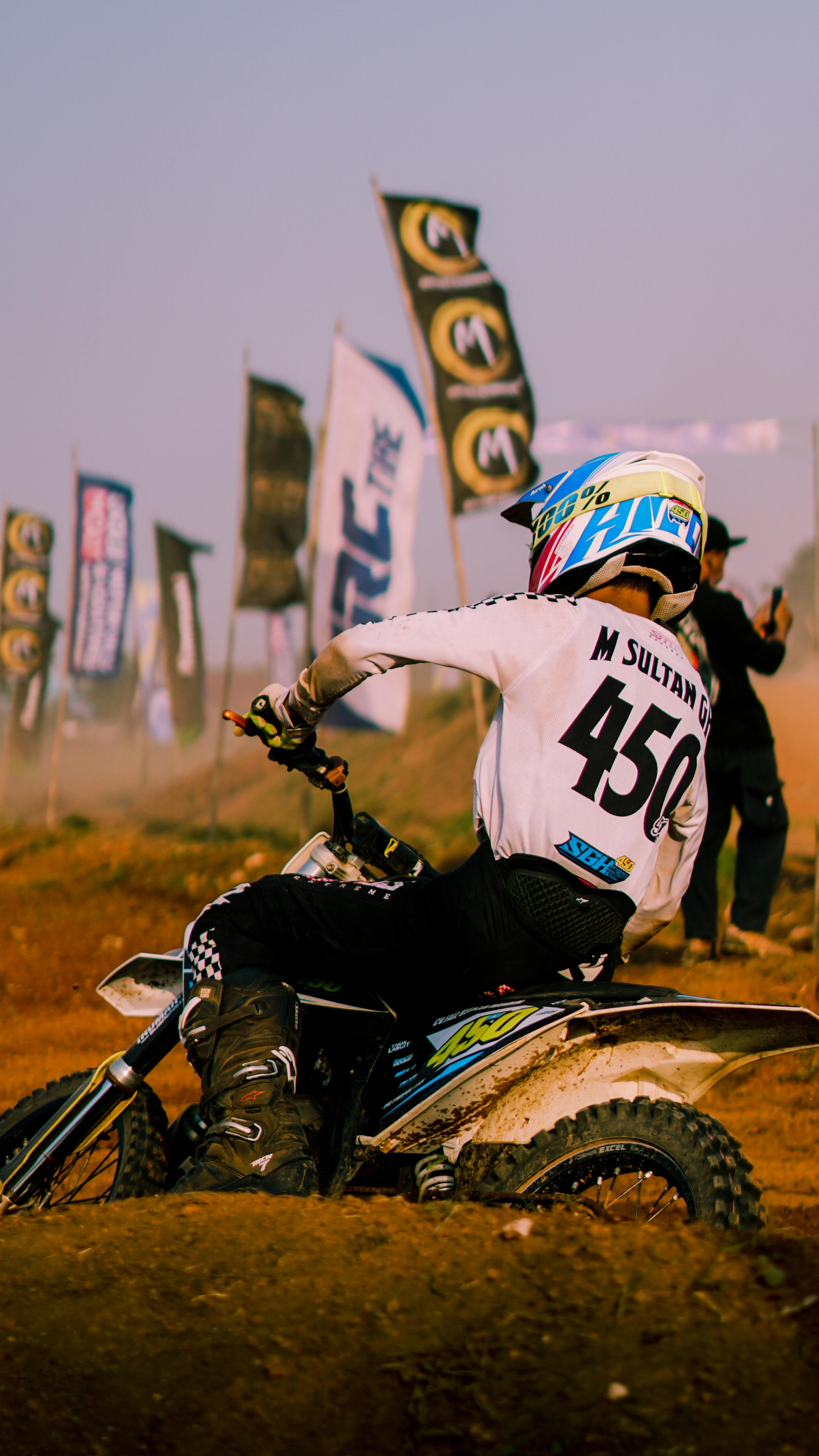 Motocross rider speeds through Jakarta's dynamic dirt track event.