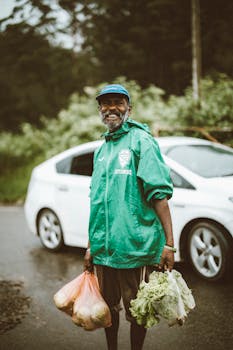 A joyful man in Sri Lanka holds groceries by a roadside, showcasing local lifestyle.