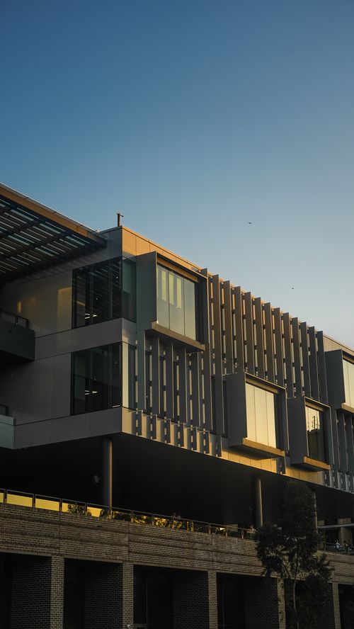 Free Contemporary architectural design of an office building during sunset with a clear blue sky. Stock Photo