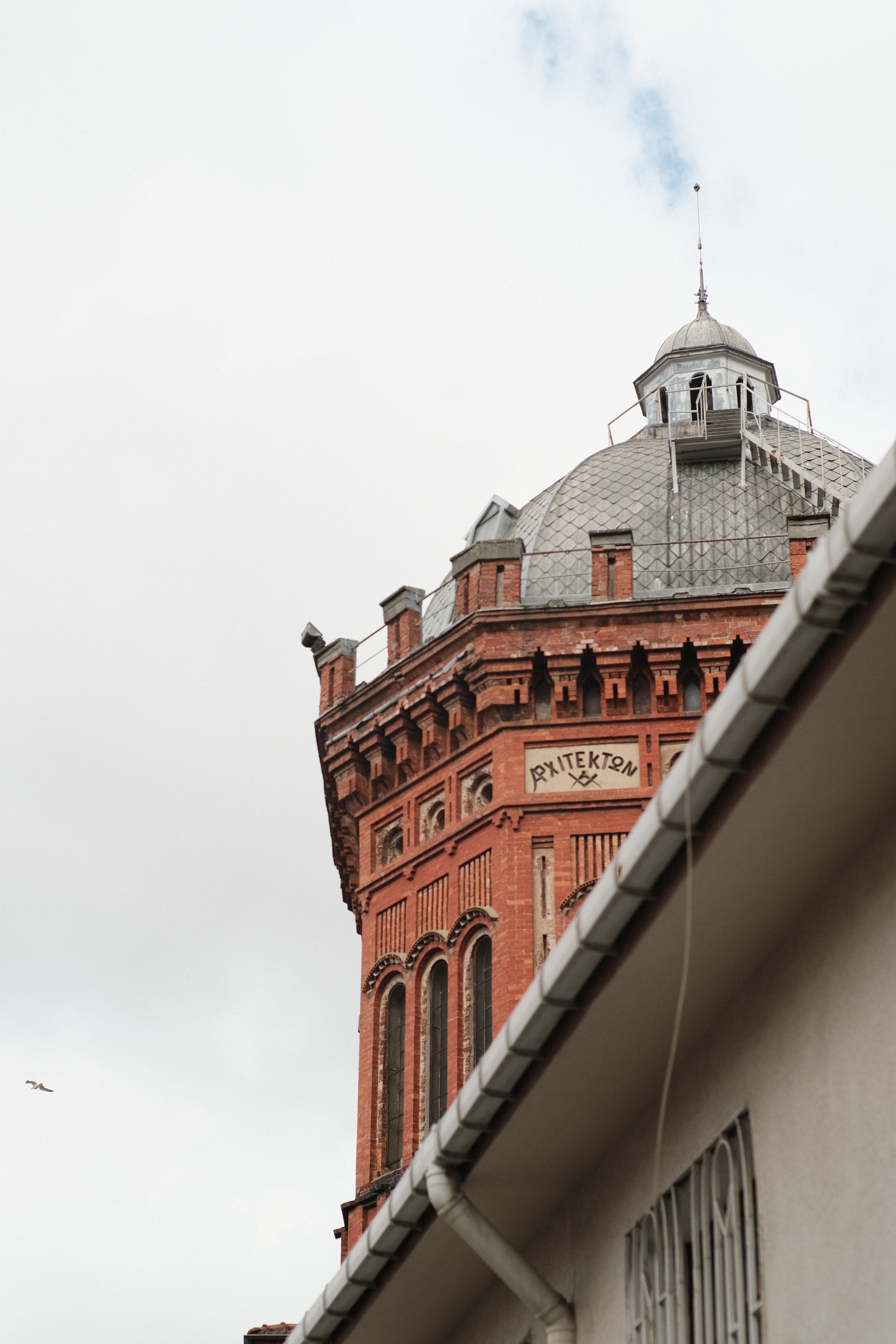 Historic Red Brick Tower Against Cloudy Sky · Free Stock Photo
