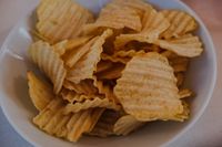 Ridged potato chips in a white bowl — photo by Markus Winkler on Pexels