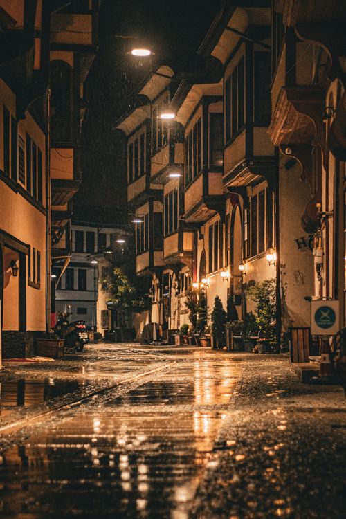 Free Beautiful night street with illuminated traditional buildings and rain reflections. Stock Photo