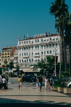 Street view of the Splendid Hotel in Cannes with people walking by on a sunny day.