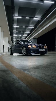 A stylish car parked in an illuminated urban garage at night. Modern and minimalist.