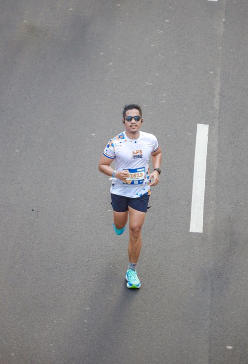 Free Aerial view of a male runner participating in a city marathon on a clear day. Stock Photo