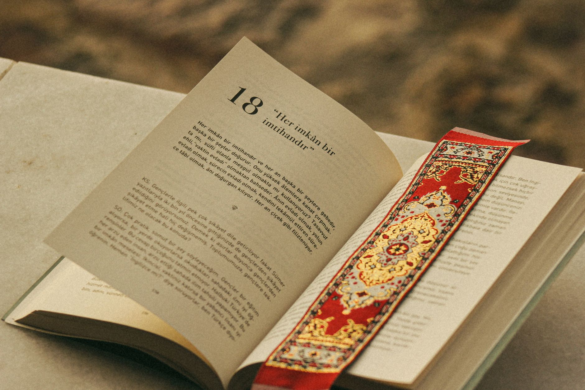 Open book with a red decorated bookmark placed on a table, inviting readers.