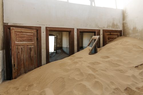 Free Interior of an abandoned house filled with sand dunes in Kolmanskop, Namibia. Stock Photo