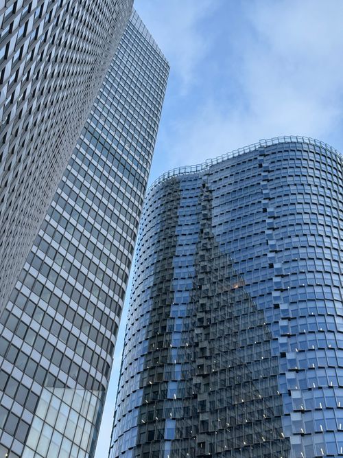 Free View of towering modern skyscrapers in La Défense, Paris under a blue sky. Stock Photo
