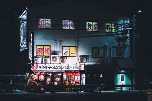 Free A neon-lit ramen shop in an urban area at night, exuding vibrant city life. Stock Photo