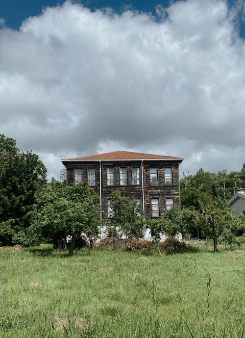 Free Charming old wooden house amidst greenery in İstanbul, Türkiye, under a cloudy sky. Stock Photo
