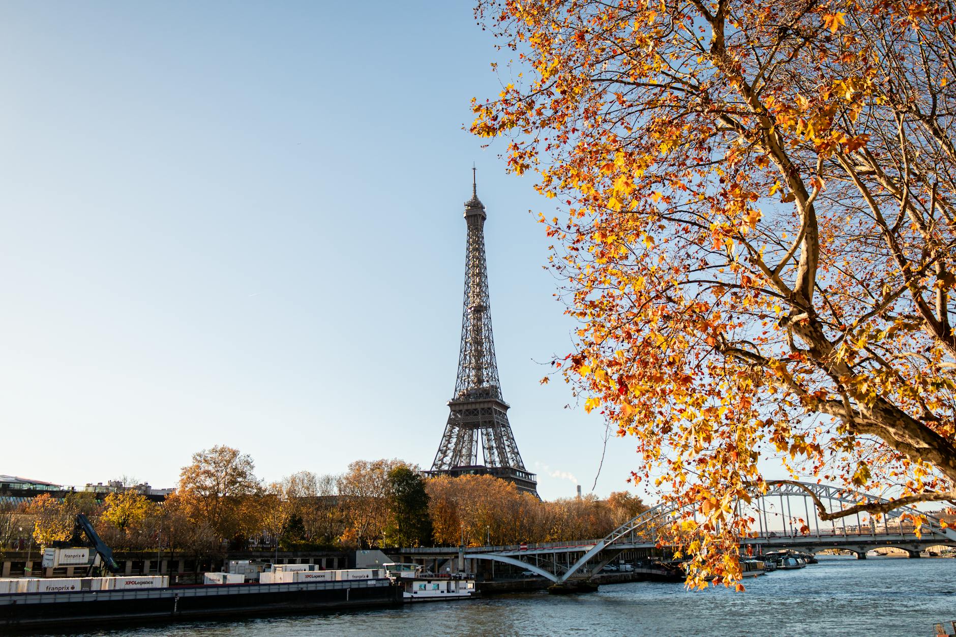 Fall travel 2025 autumn getaways 2025 Eiffel Tower amid golden trees in Paris from Seine