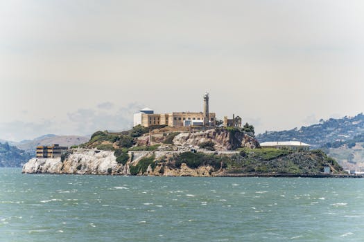 Scenic view of Alcatraz Island and prison from San Francisco Bay, California, in daylight.