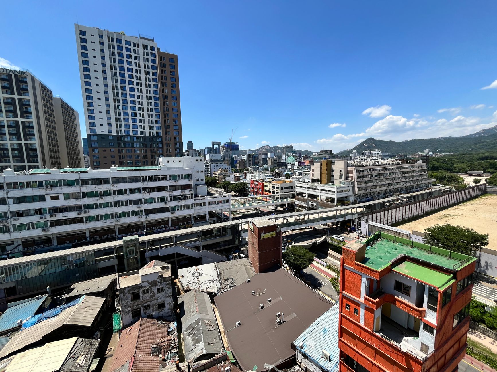 Aerial view of a bustling cityscape with skyscrapers under a clear blue sky.