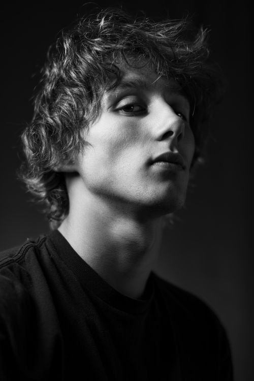 Free Striking black and white portrait of a young man with intense gaze. Stock Photo