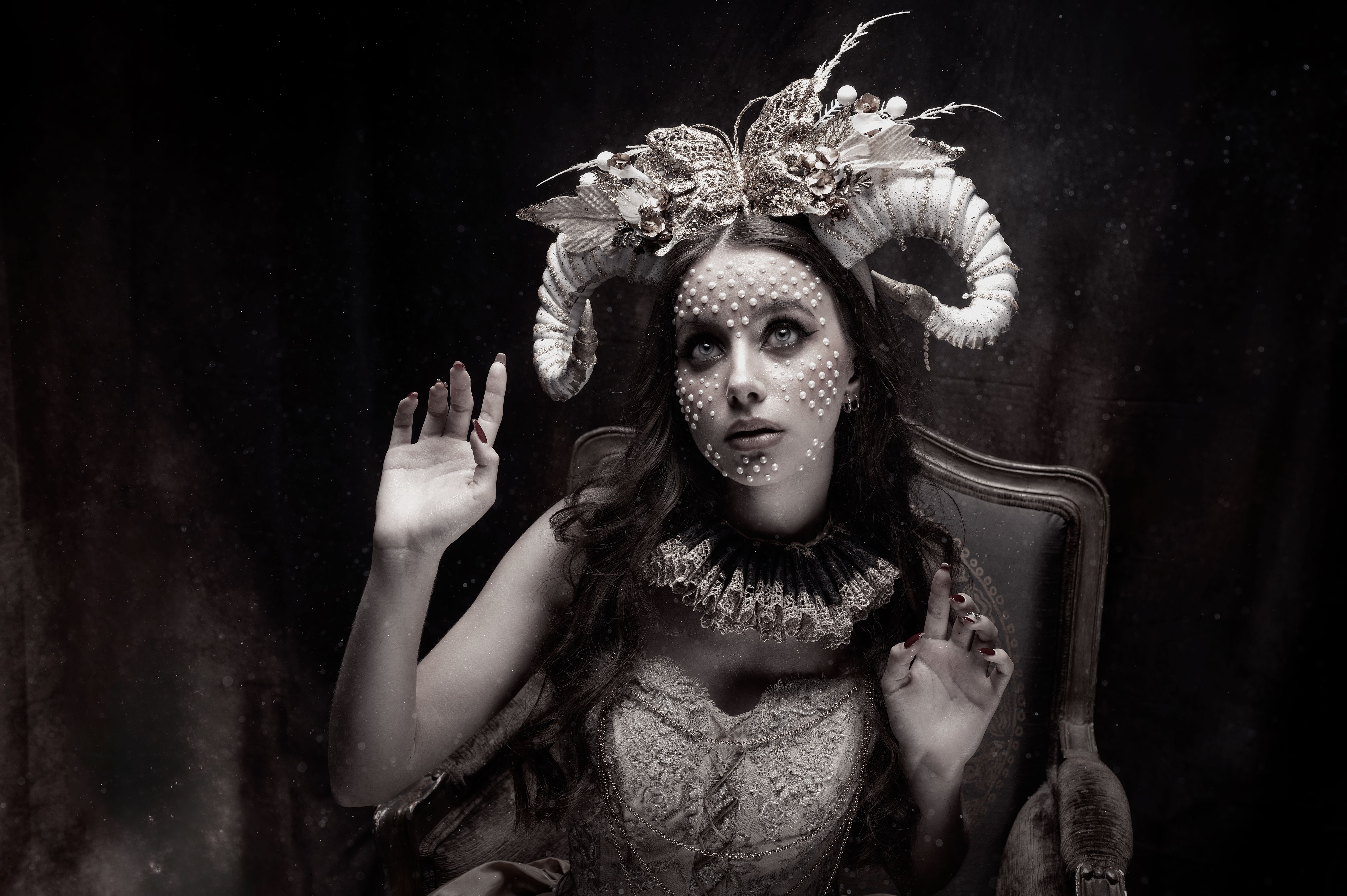 Elegant fantasy portrait of a woman in costume with decorative horns and pearls.