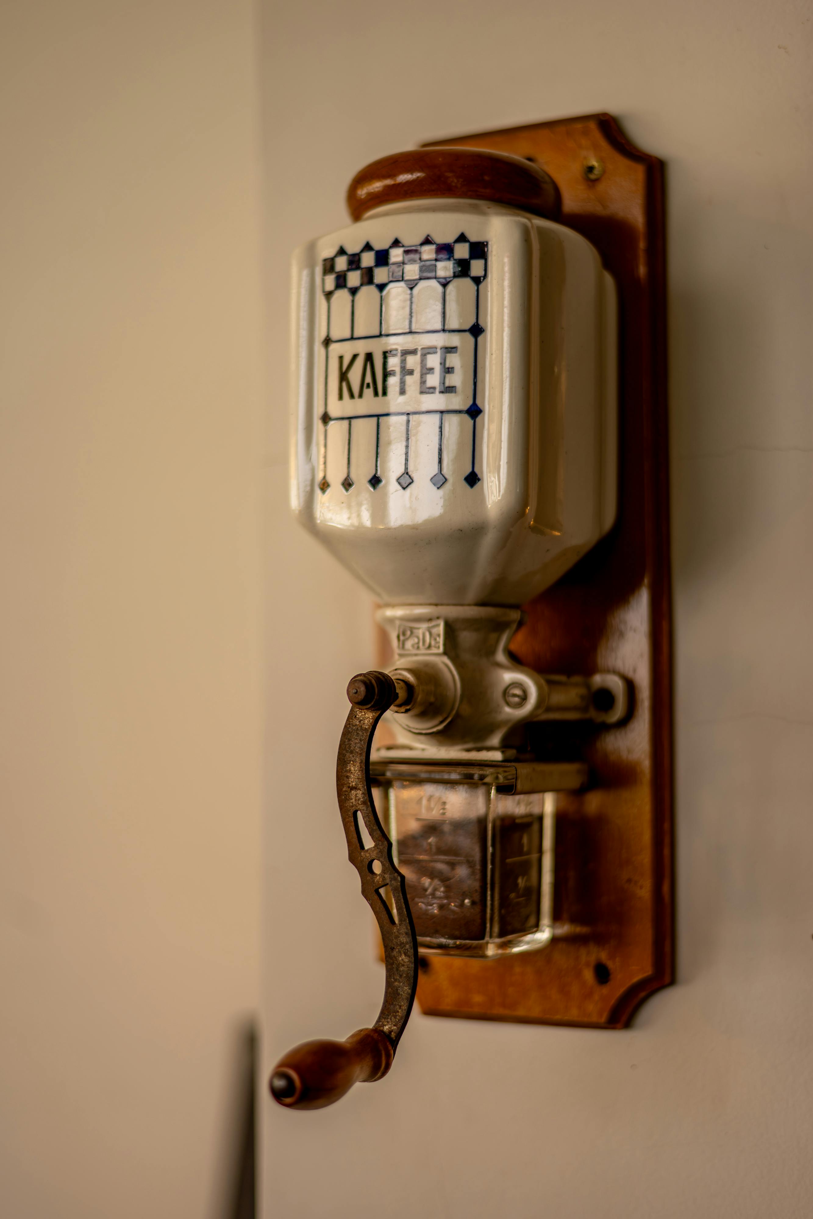 gratis Een klassieke, vintage koffiemolen voor aan de muur, met een ingewikkeld ontwerp en houten handvat. Stockfoto