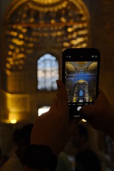 Photo of a historic building's interior captured via smartphone, with warm lighting.