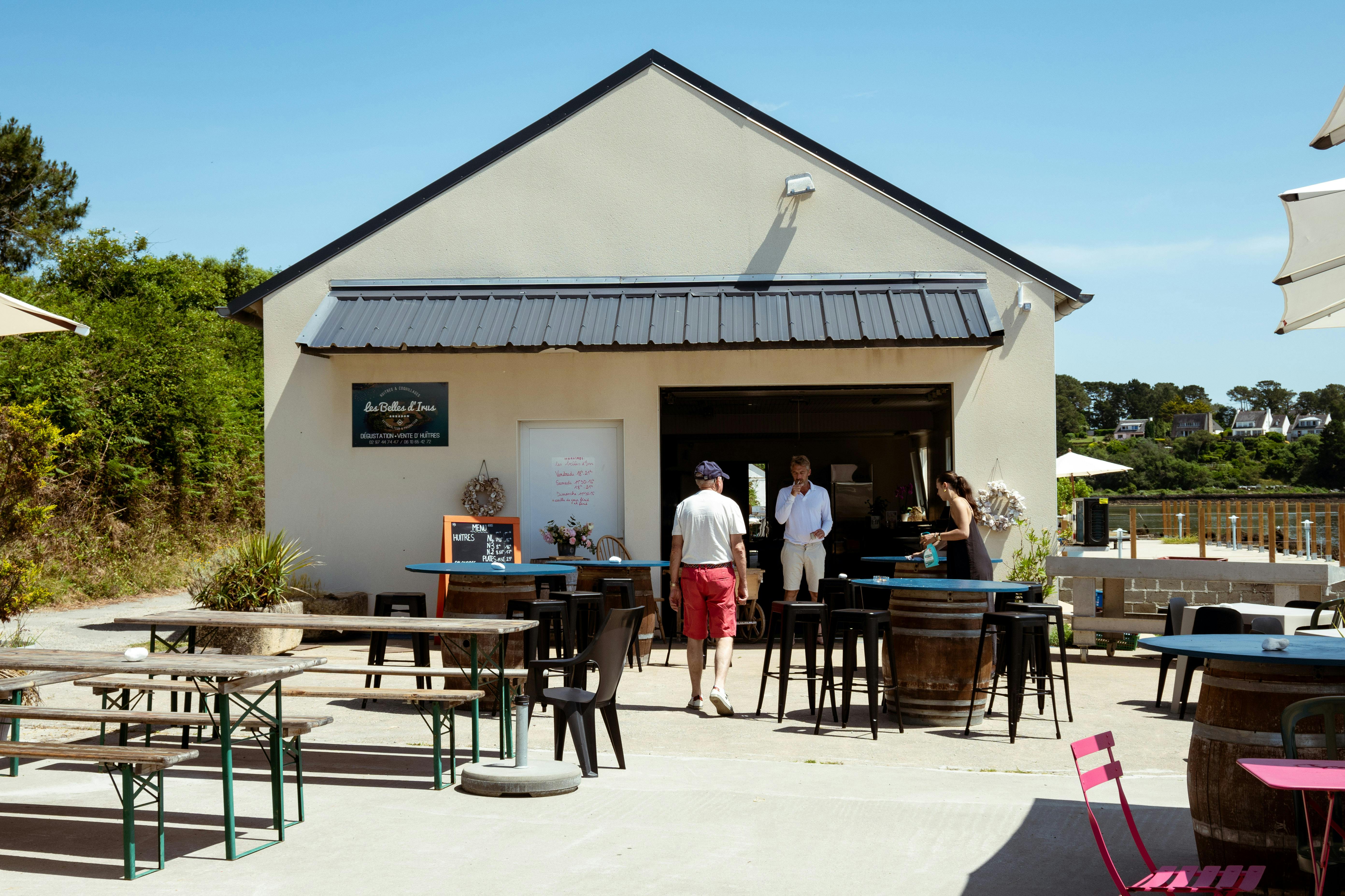 Free Charming outdoor café setting with people enjoying a sunny day. Relaxed and inviting atmosphere. Stock Photo
