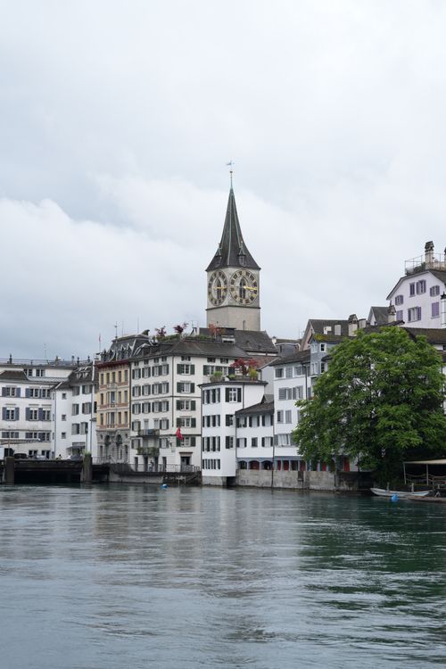 Free Scenic view of Zurich's Old Town featuring the iconic St. Peter's Church by the river. Stock Photo