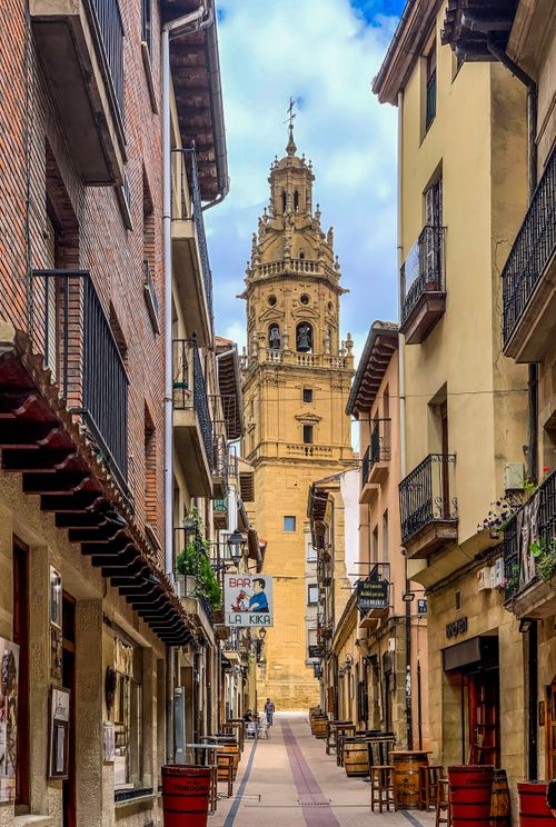 Free Scenic street view featuring a historic bell tower amidst traditional European architecture. Stock Photo