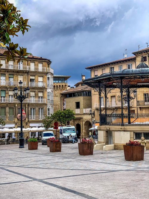 Free Scenic view of a European plaza featuring historic buildings and a gazebo under a cloudy sky. Stock Photo