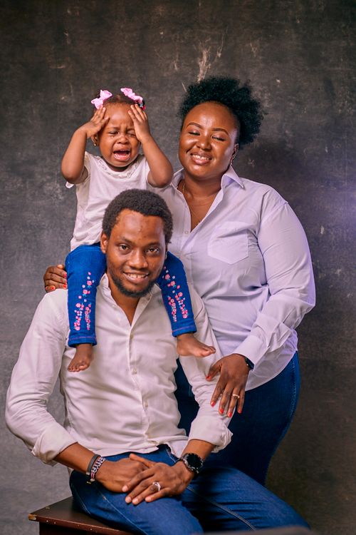 Free A joyful family portrait featuring parents with their young daughter. Stock Photo