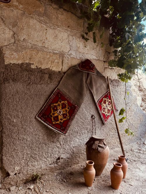 Free Traditional textile decor with clay pots against a rustic wall, evoking cultural heritage. Stock Photo