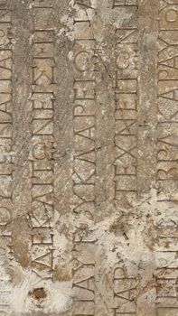 Close-up of an ancient stone slab featuring Greek inscriptions, weathered by time.
