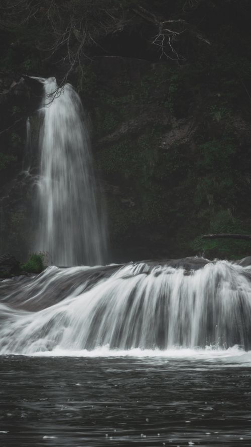 Free Peaceful waterfall cascading through lush greenery in Villa La Angostura, Argentina. Stock Photo