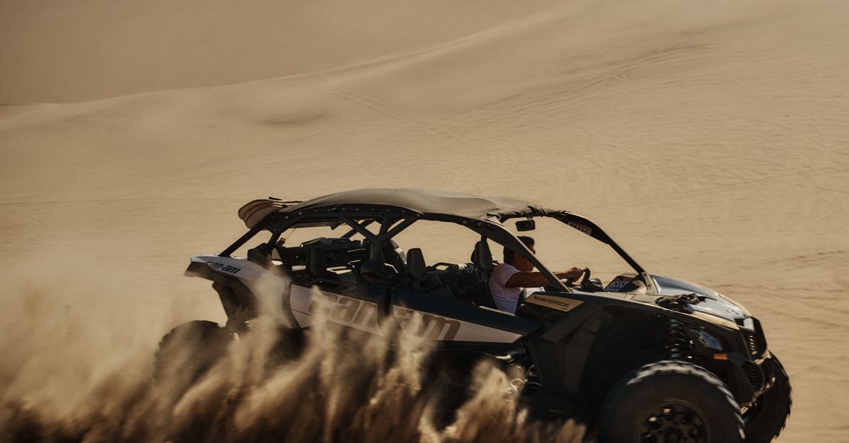 Dynamic off-road vehicle racing through expansive desert dunes, showcasing adventure and thrill.