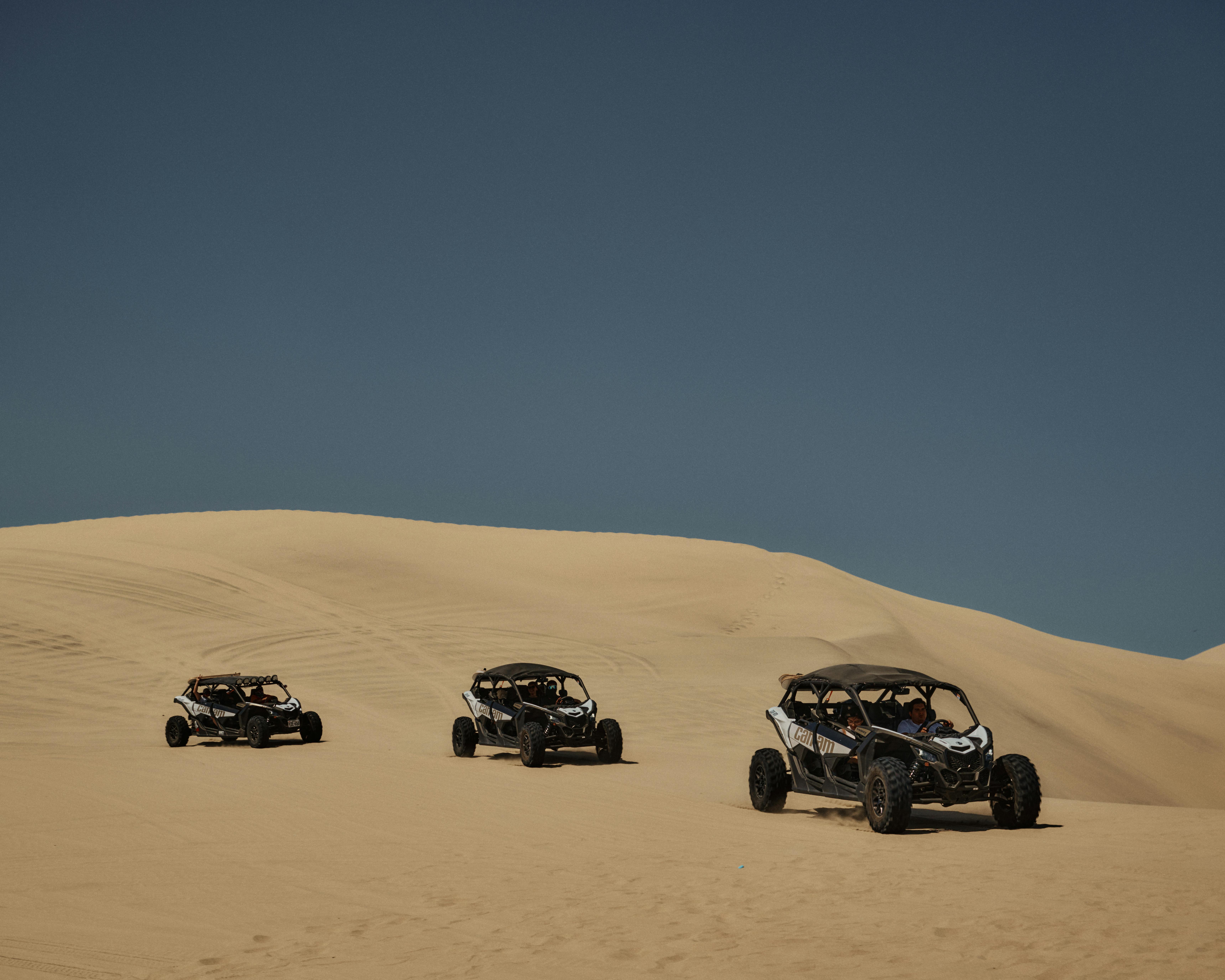 Explore thrilling off-road adventures across vast desert dunes under a clear blue sky.