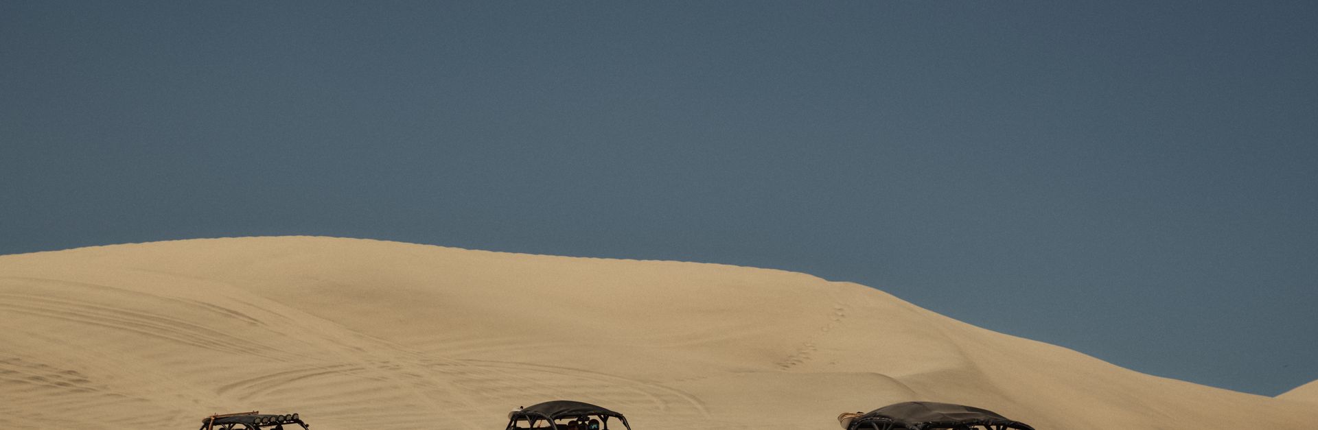 Explore thrilling off-road adventures across vast desert dunes under a clear blue sky.