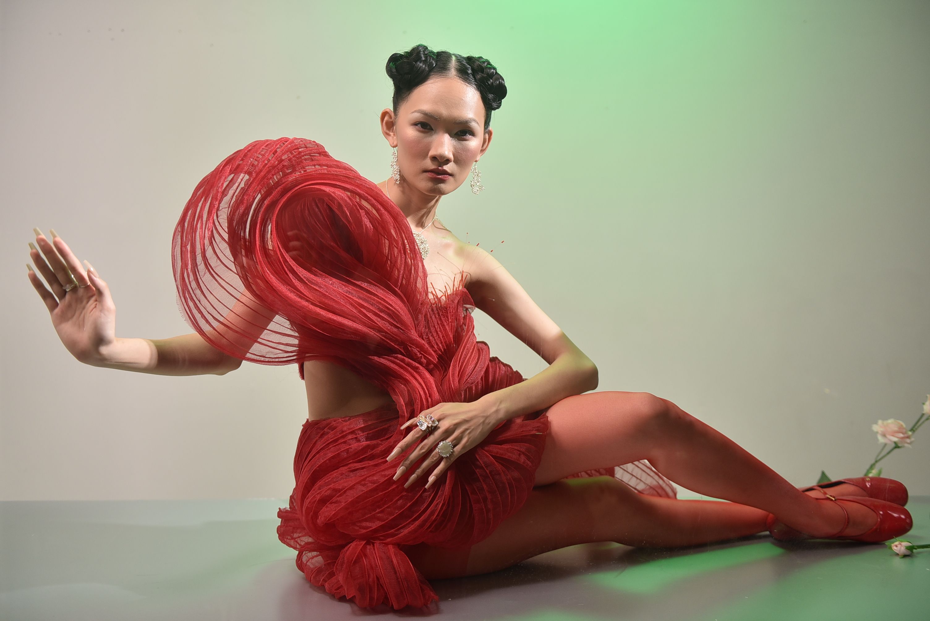 Artistic portrait of a woman in a dramatic red dress with an avant-garde design.