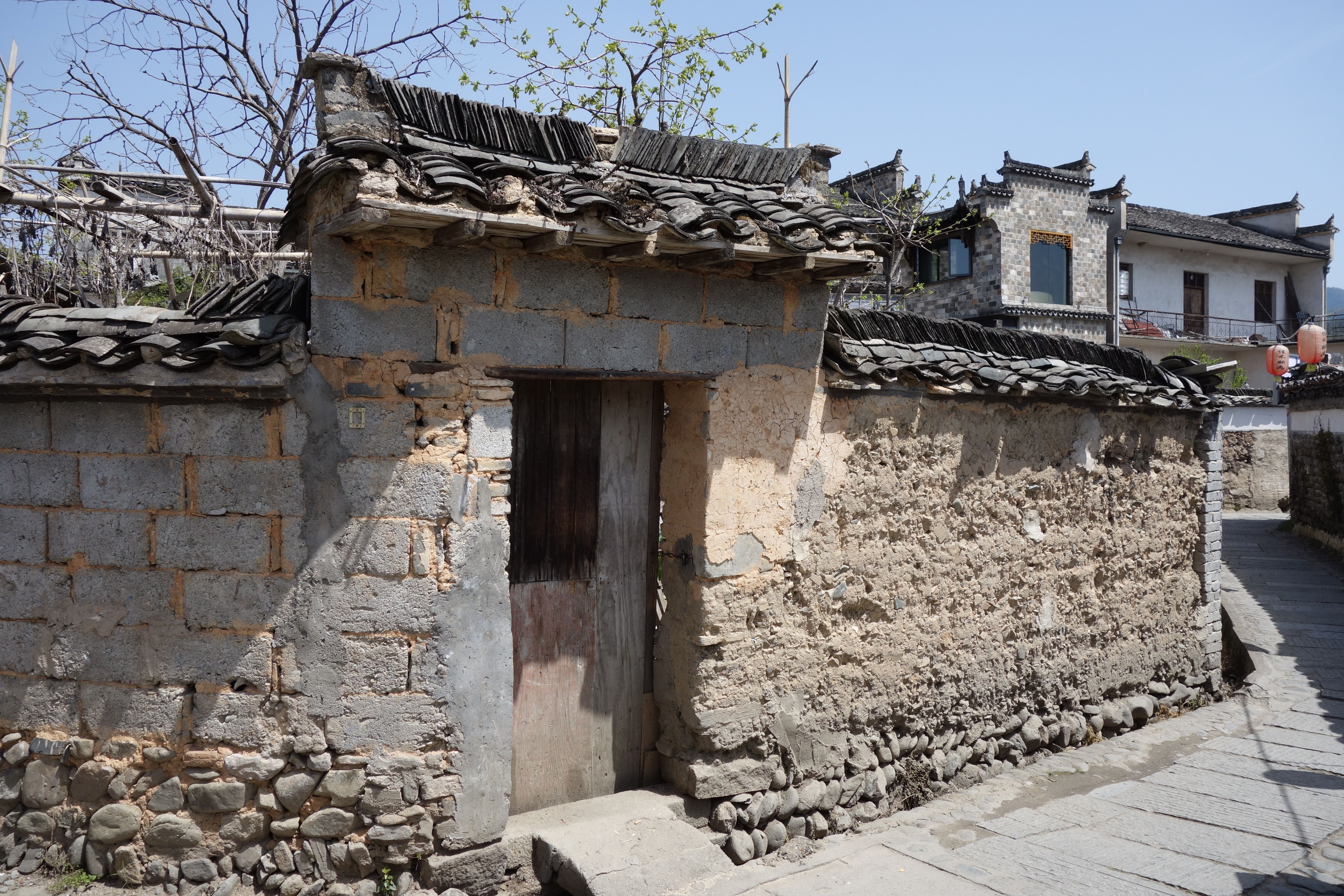 A quiet alley in an ancient Huizhou village with white walls and grey tiles