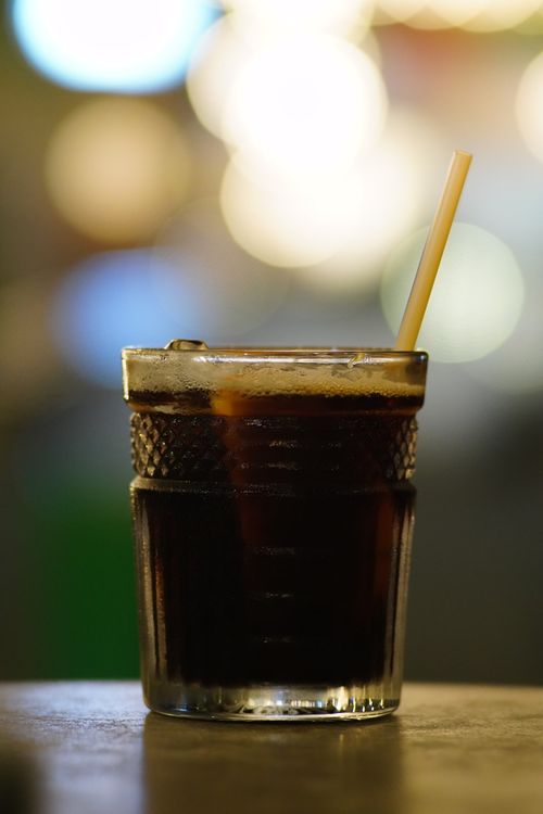Free Close-up of a cold cola beverage in a glass with a straw, perfect for refreshing moments. Stock Photo