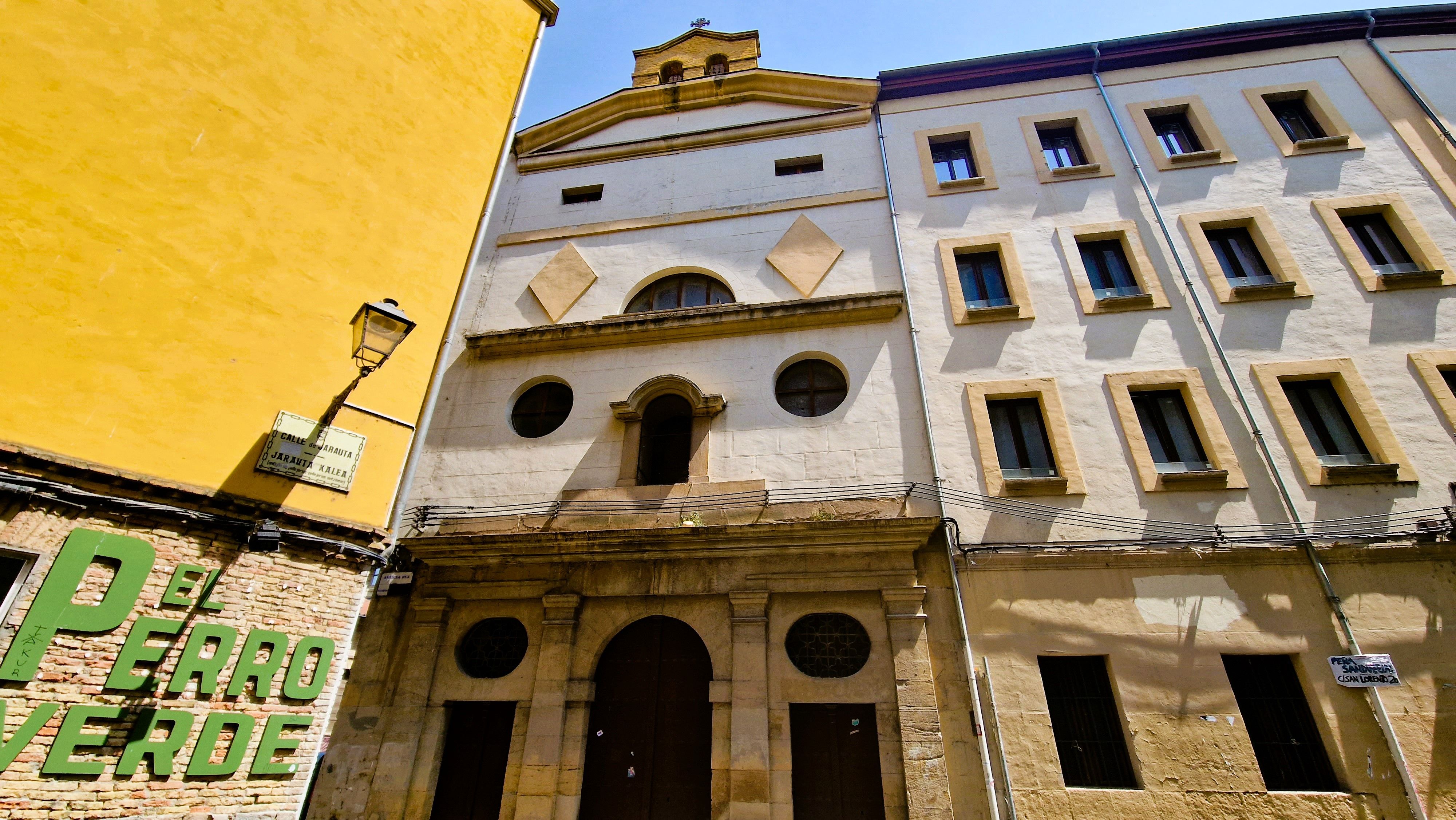Facade of historic building with urban elements in Spain under bright daylight.