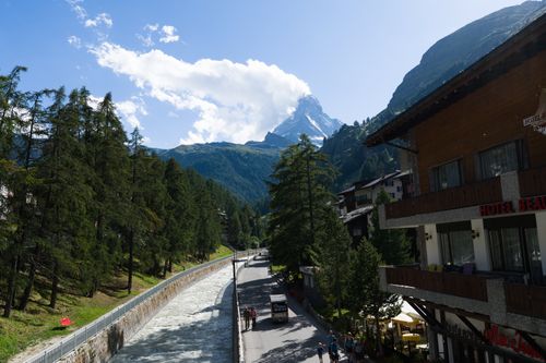 Scenic view of the Matterhorn from Zermatt with alpine architecture and flowing river.