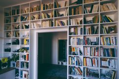 A cozy indoor library with floor-to-ceiling bookshelves filled with books, creating a serene reading nook.