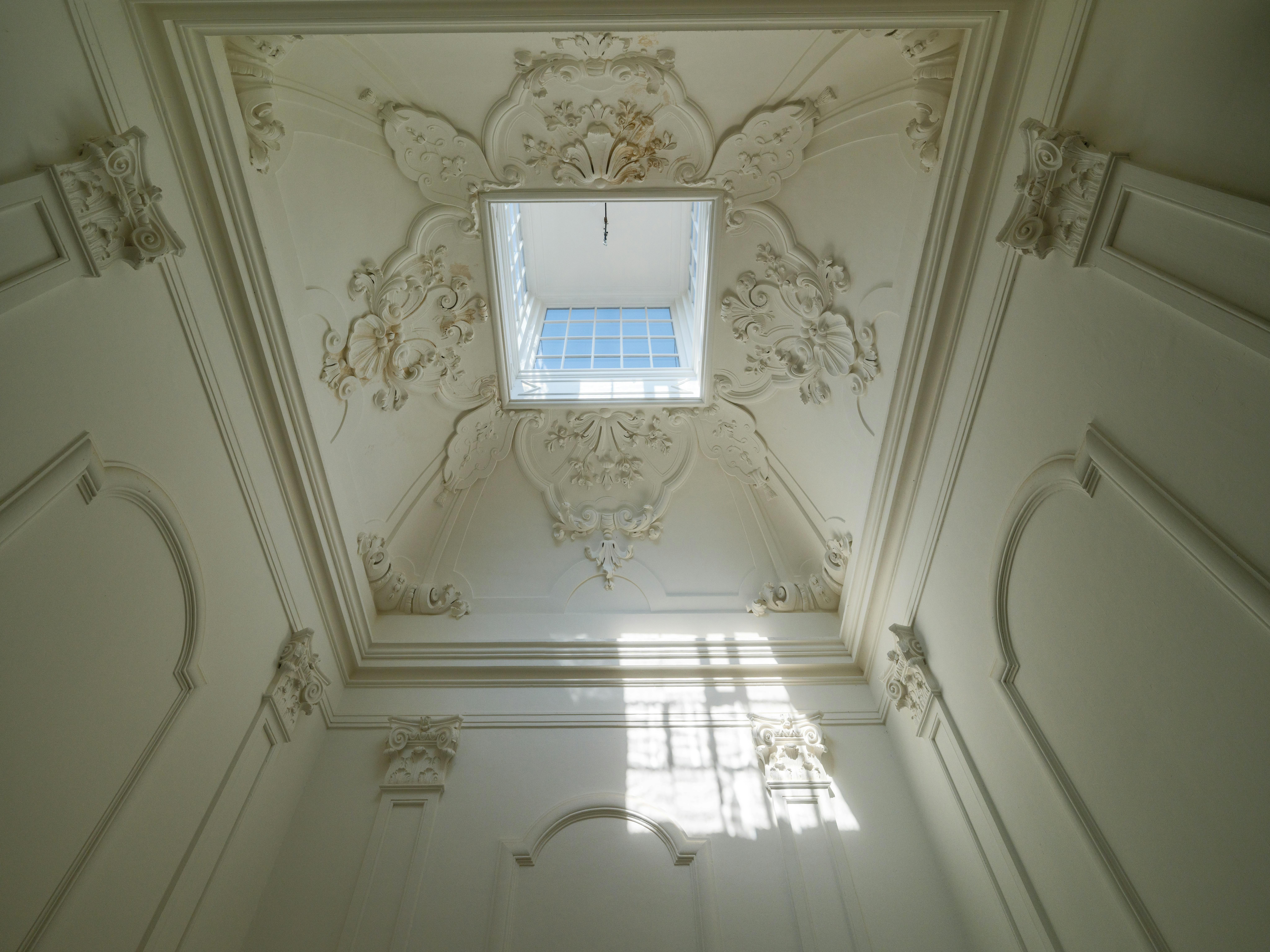 Sufit z tynkiem akustycznym w biurze open space, widoczne oprawy i jednolita powierzchnia