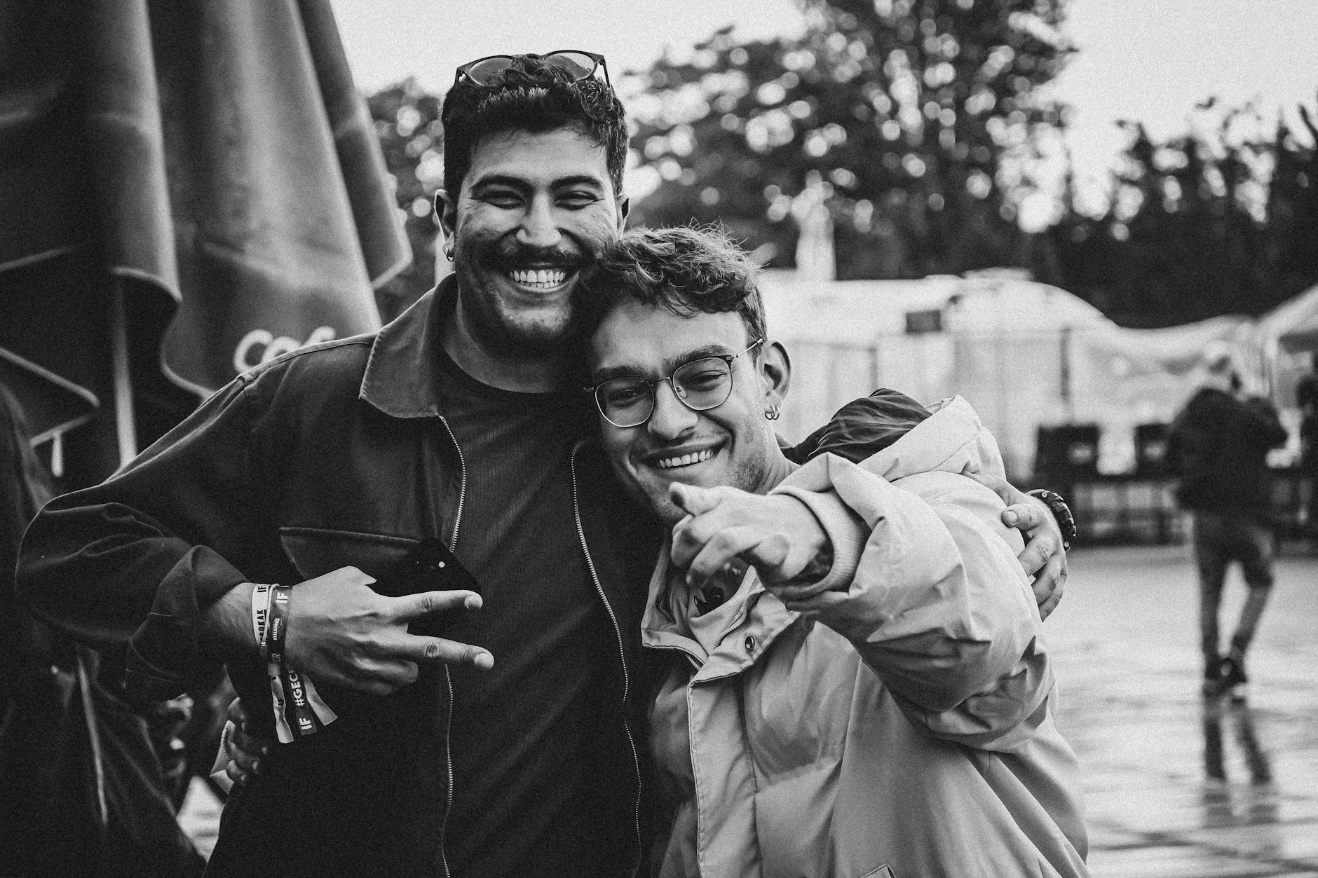 Two friends smiling and having fun at an outdoor music festival in Ankara, Türkiye.