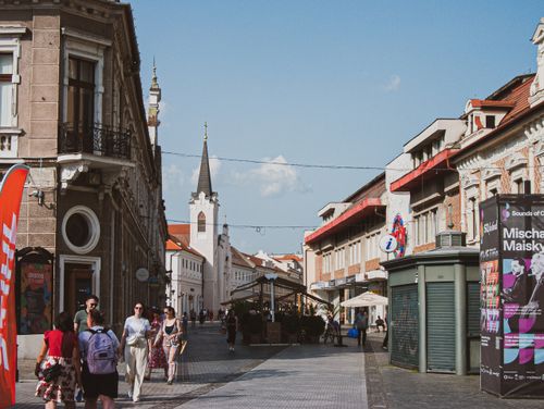Free Street view featuring historical architecture and people in a European city, capturing a lively urban atmosphere. Stock Photo