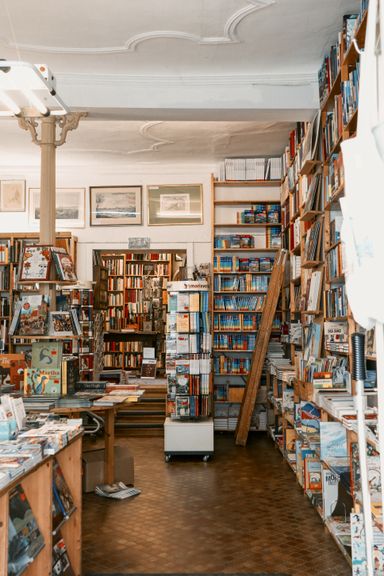 Stacks of books and a wooden ladder in an old bookshop