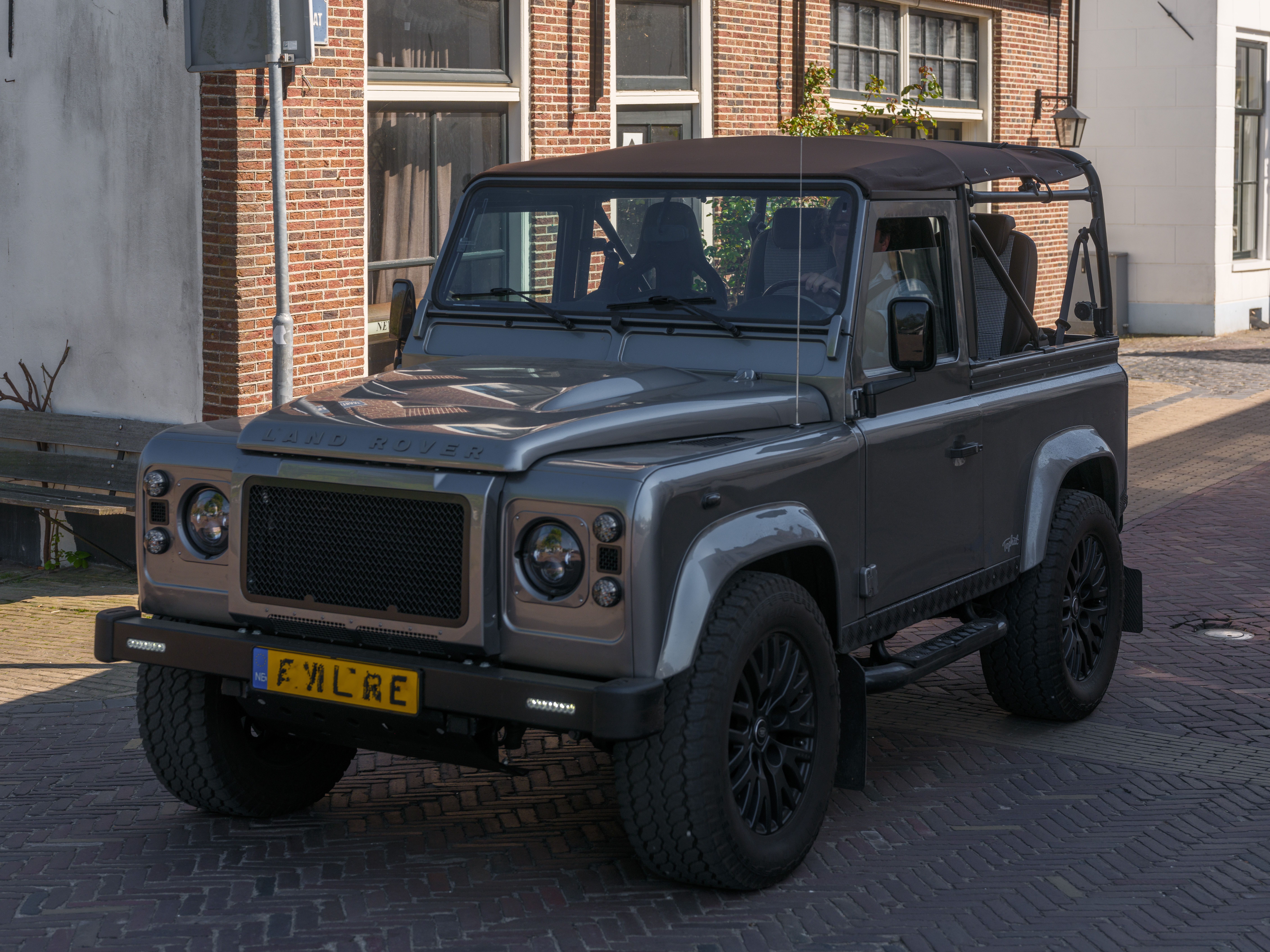 Land Rover parked on a cobblestone street on a sunny day.