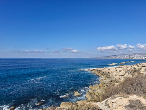 Free A breathtaking coastal view with a rocky shoreline and clear blue skies. Stock Photo