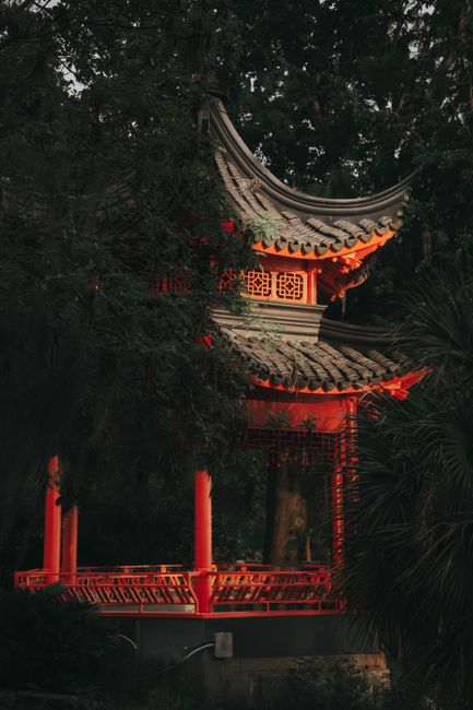 A beautifully illuminated Japanese pavilion nestled in a lush park in Orlando, FL, at twilight.