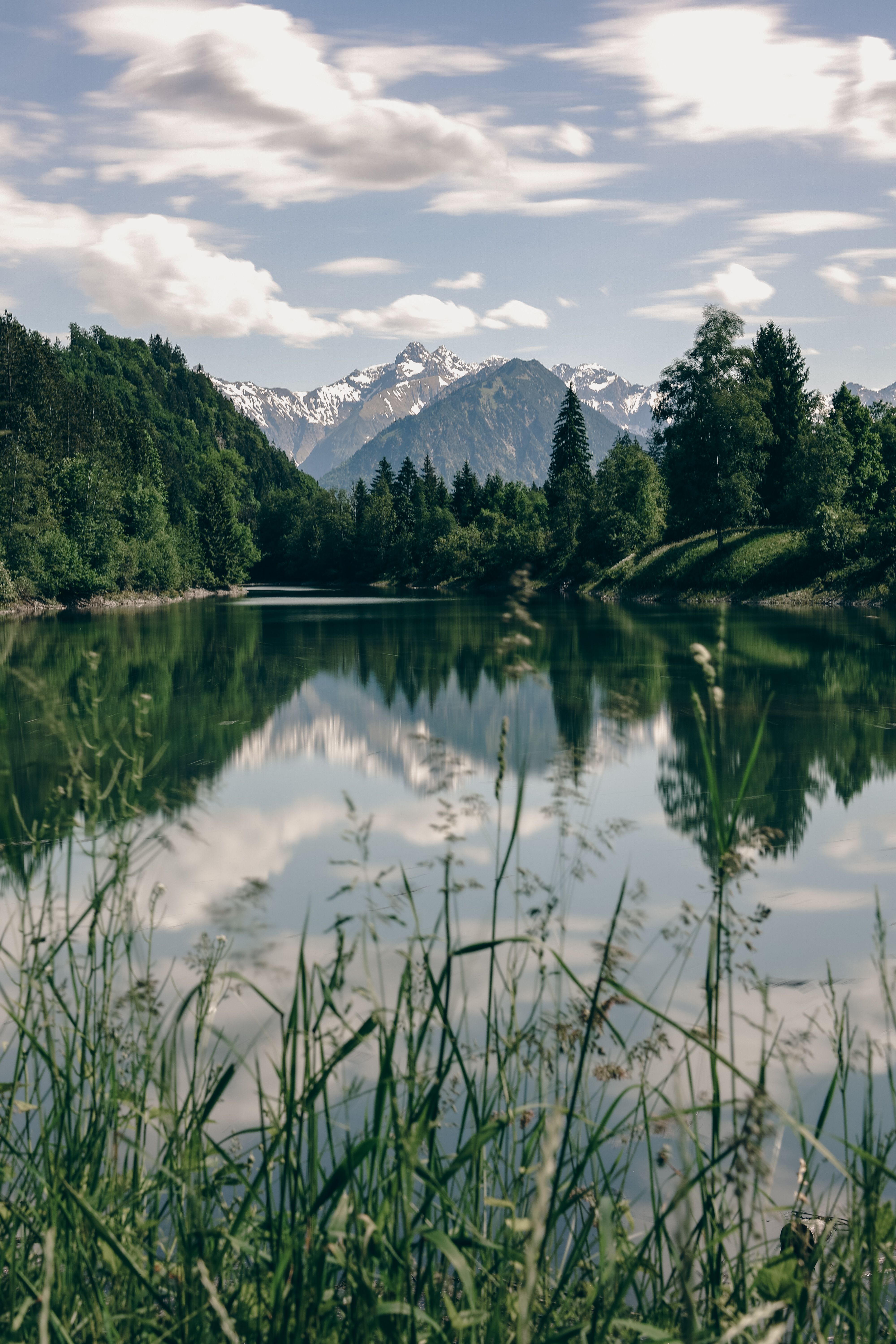 Beautiful alpine lake reflecting mountains and trees in Fischen, Bavaria, Germany.
