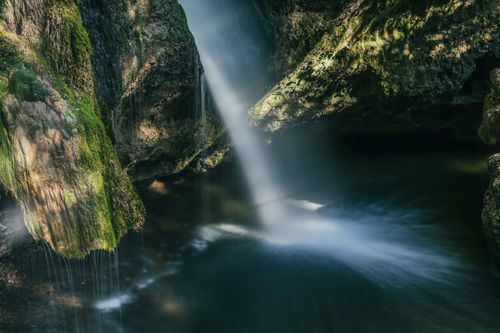 Free A tranquil waterfall cascading over mossy rocks in a peaceful forest in Sonthofen, Germany. Stock Photo