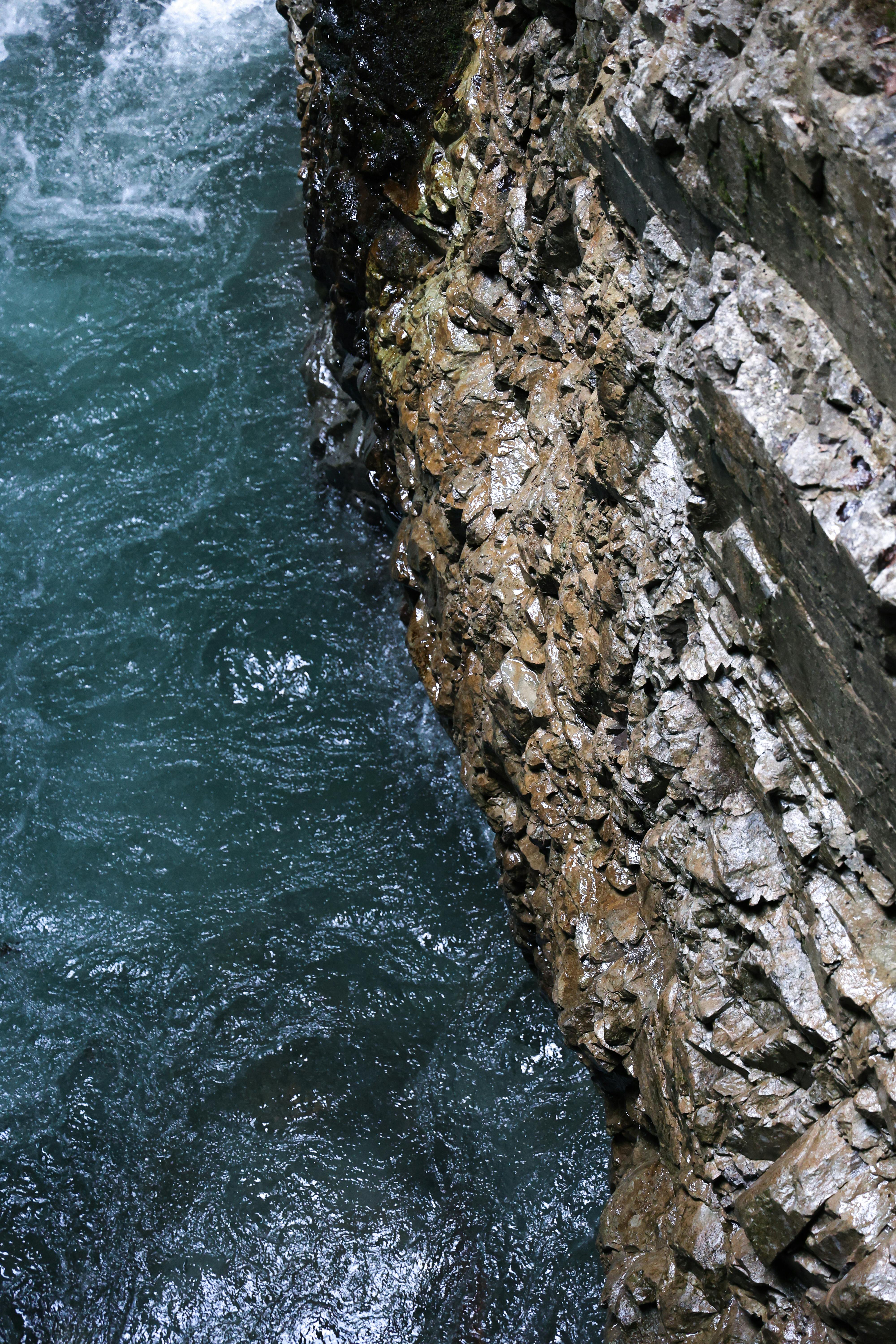 Close-up of rugged cliffs above vibrant blue waters in Breitachklamm, Oberstdorf, Germany.