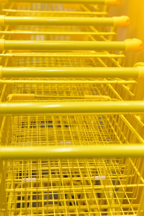 Free Close-up view of yellow shopping carts aligned in a pattern, creating a vibrant monochromatic visual. Stock Photo