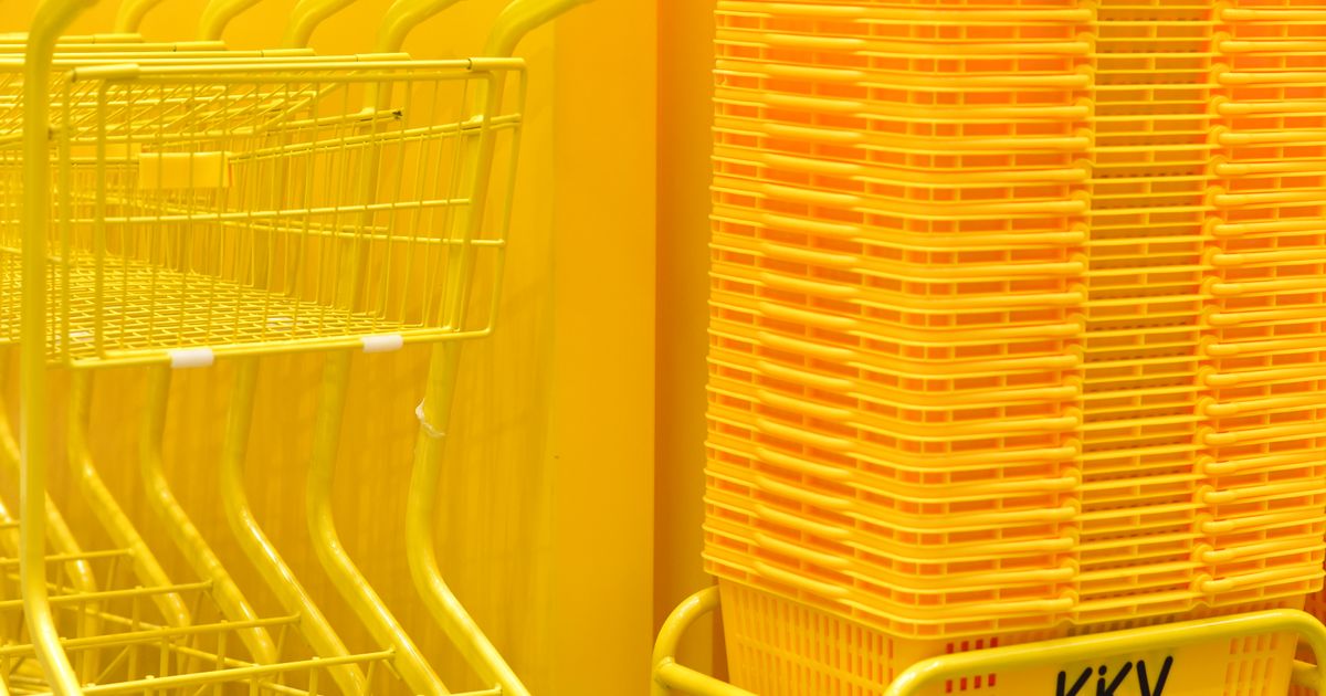 Yellow shopping carts and baskets stacked inside a store.
